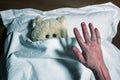 Scared teddy bear laying in bed