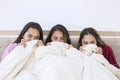 Scared teenage girls watching a horror movie in bed Royalty Free Stock Photo