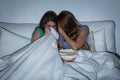 Scared teenage girls watching horror on tv at home Royalty Free Stock Photo
