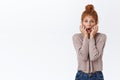 Scared, troubled shocked redhead caucasian woman with curly hair in messy bun, gasping look puzzled and insecure