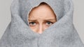 Scared woman in fear covering face with plaid/ blanket, unable to sleep after nightmare, hiding, isolated. Sleeping disorder, Royalty Free Stock Photo