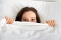 Scared woman hiding under blanket Royalty Free Stock Photo