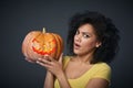 Scared woman holding Halloween pumpkin
