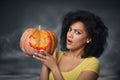 Scared woman holding Halloween pumpkin