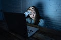 Scared woman on laptop in the dark feeling fear suffering online harassment and cyberbullying Royalty Free Stock Photo