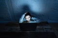 Scared woman on laptop in the dark feeling fear suffering online harassment and cyberbullying Royalty Free Stock Photo