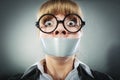 Scared woman with mouth taped shut. Censorship. Royalty Free Stock Photo