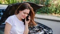 Scared woman in stress after auto crash calling to auto insurance for help. Driver woman crying in front of wrecked car in car Royalty Free Stock Photo