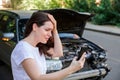 Scared woman in stress holding her head after auto crash calling to auto insurance for help. Driver woman in front of wrecked car Royalty Free Stock Photo