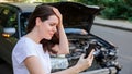 Scared woman in stress holding her head after auto crash calling to auto insurance for help. Driver woman in front of wrecked car Royalty Free Stock Photo