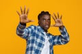 Scared young black man in plaid shirt raising hands and saying stop Royalty Free Stock Photo