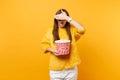 Scared young girl in 3d imax glasses covering face with palm, watching movie film, holding bucket of popcorn isolated on