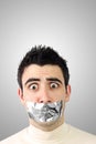 Scared young man having gray duct tape on mouth Royalty Free Stock Photo