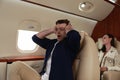 Scared young man suffering from aviophobia in airplane Royalty Free Stock Photo