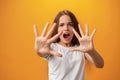 Scared young teen girl showing stop gesture against yellow background Royalty Free Stock Photo
