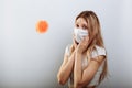 Scared young woman in medical mask standing near covid-19 virus molecule. Concept of coronavirus and Asian flu panic Royalty Free Stock Photo