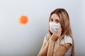 Scared young woman in medical mask standing near covid-19 virus molecule. Concept of coronavirus and Asian flu panic Royalty Free Stock Photo