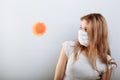 Scared young woman in medical mask standing near covid-19 virus molecule. Concept of coronavirus and Asian flu panic Royalty Free Stock Photo