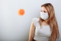 Scared young woman in medical mask standing near covid-19 virus molecule. Concept of coronavirus and Asian flu panic Royalty Free Stock Photo