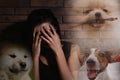 Scared young woman suffering from cynophobia near wall. Irrational fear of dogs