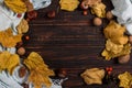 Scarf, chestnuts, nuts and dry leaves on a wooden table. Autumn background, copy space