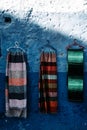 Scarfs on vibrant blue wall Colorful scarfs adorn a captivating blue backdrop, creating a visually dynamic display