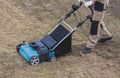 Scarifying lawn with scarifier, Man gardener scarifies the lawn and removal of old grass Royalty Free Stock Photo