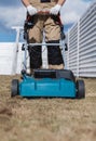 Scarifying lawn with scarifier, Man gardener scarifies the lawn and removal of old grass Royalty Free Stock Photo