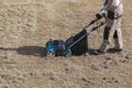 Scarifying lawn with scarifier, Man gardener scarifies the lawn and removal of old grass