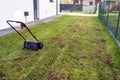 Scarifying the lawn before the winter season using an electric scarifier.