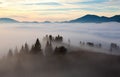 Scarlet, red, orange, yellow stripes on the horizon of the dawn sky covered with clouds in the mountains. Royalty Free Stock Photo