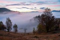 Scarlet, red, orange, yellow stripes on the horizon of the dawn sky covered with clouds in the mountains. Royalty Free Stock Photo