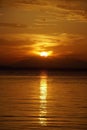 Scarlet red sunset over the sea. September in Greece. Sithonia. The sun and clouds and unusual colors. Glare on the water.