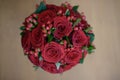 Scarlet roses and berries floral arrangement set on a table, view from above