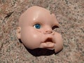 Scary and broken doll face with one blue eye on a background of stone Royalty Free Stock Photo