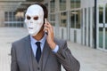 Scary businessman wearing a mask calling by phone Royalty Free Stock Photo