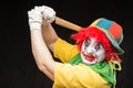 Scary clown joker with a smile and red hair with a big knife on