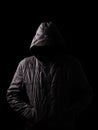 Scary and creepy man hiding in the shadows, with the face and identity hidden with the hood Royalty Free Stock Photo
