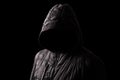 Scary and creepy man hiding in the shadows, with the face and identity hidden with the hood Royalty Free Stock Photo