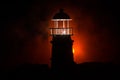 Scary dark ominous lighthouse behind a red fire background. Lighthouse at dusk/ Sunset Light House/ Light house at sunset. Decorat Royalty Free Stock Photo