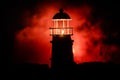 Scary dark ominous lighthouse behind a red fire background. Lighthouse at dusk/ Sunset Light House/ Light house at sunset. Decorat Royalty Free Stock Photo