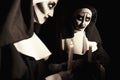 Scary devilish nun with burning candle near mirror on black background. Halloween party look Royalty Free Stock Photo