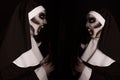 Scary devilish nun near mirror on black background. Halloween party look Royalty Free Stock Photo