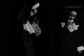 Scary devilish nun near mirror on black background. Halloween party look Royalty Free Stock Photo