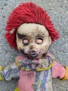 scary dirty and spoiled doll with closed eyes on the pavement Royalty Free Stock Photo
