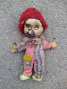 scary dirty and spoiled doll with closed eyes on the pavement Royalty Free Stock Photo