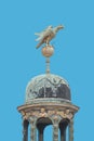 Scary Eagle standing at the globe of some of the roof at Saint Nicholas Church in the historical downtown with blue sky background