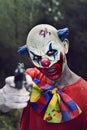 Scary evil clown with a gun