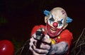 Scary evil clown with a gun