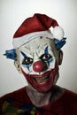 Scary evil clown with a santa hat